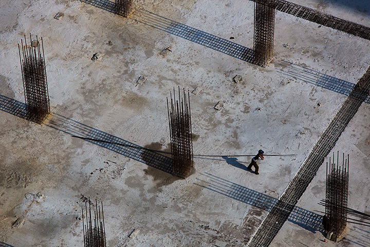 24 hours: Pyongyang, North Korea: A construction worker pulls a steel rod 