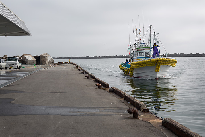 Soma, Japan: Early morning and the first of 5 fishing boats arrives