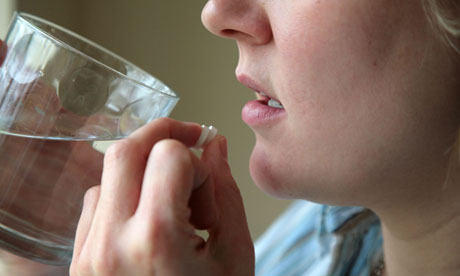 Woman taking pills with water