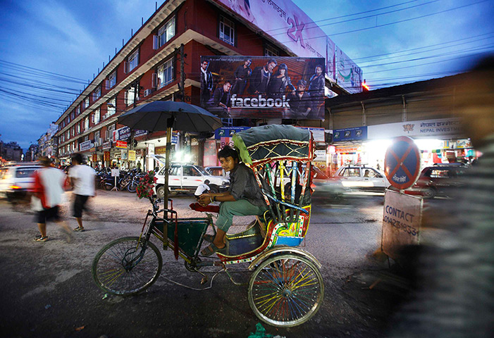 24 hours: Kathmandu, Nepal: A rickshaw driver waits for passengers 