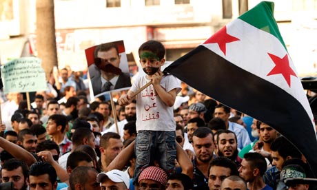 A boy holds a pre-Baath Syrian flag, ado