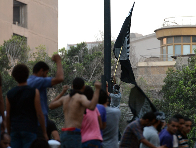 Benghazi protest: Egyptian protesters raise a black flag inside the US embassy