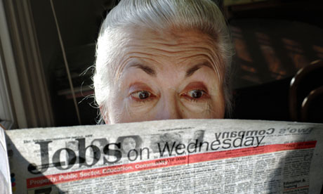 A surprised looking woman pensioner surveys the jobs on offer in her local paper.
