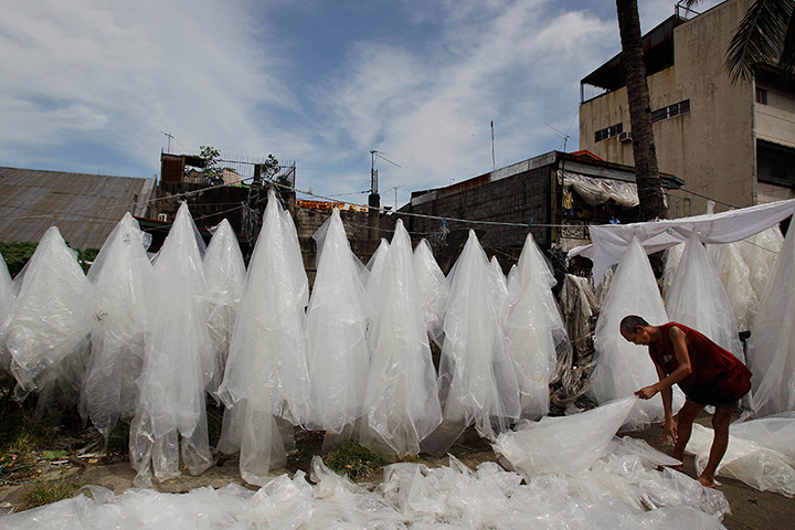 24 hours: Caloocan, Philippines: A worker picks up used plastic sheets 