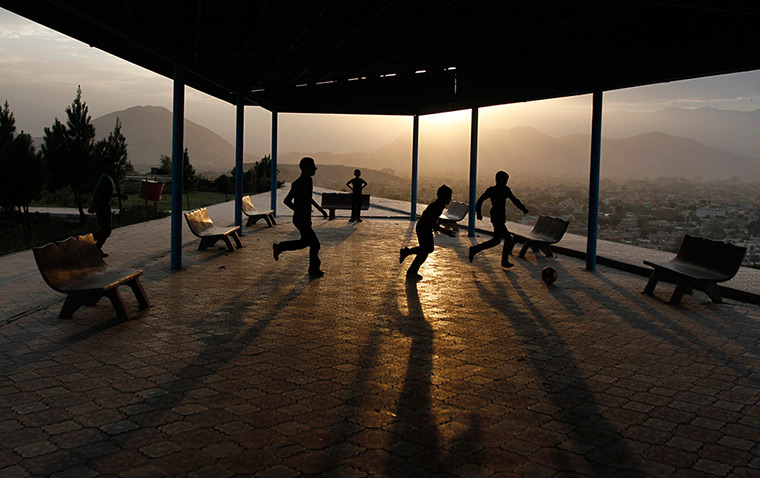 24 hours: Kabul, Afghanistan: Afghan boys play football on a hill