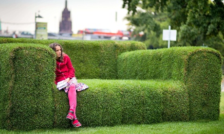 A woman sits on a grass-made sofa in Frankfurt, Germany. The so-called 