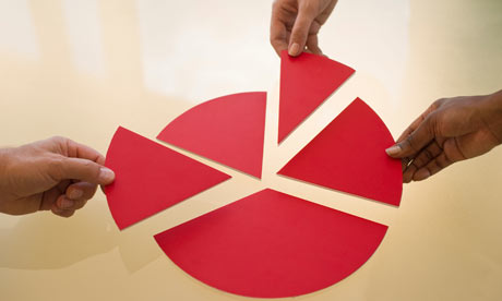 Hands dividing pieces of pie chart. Image shot 2010. Exact date unknown.
