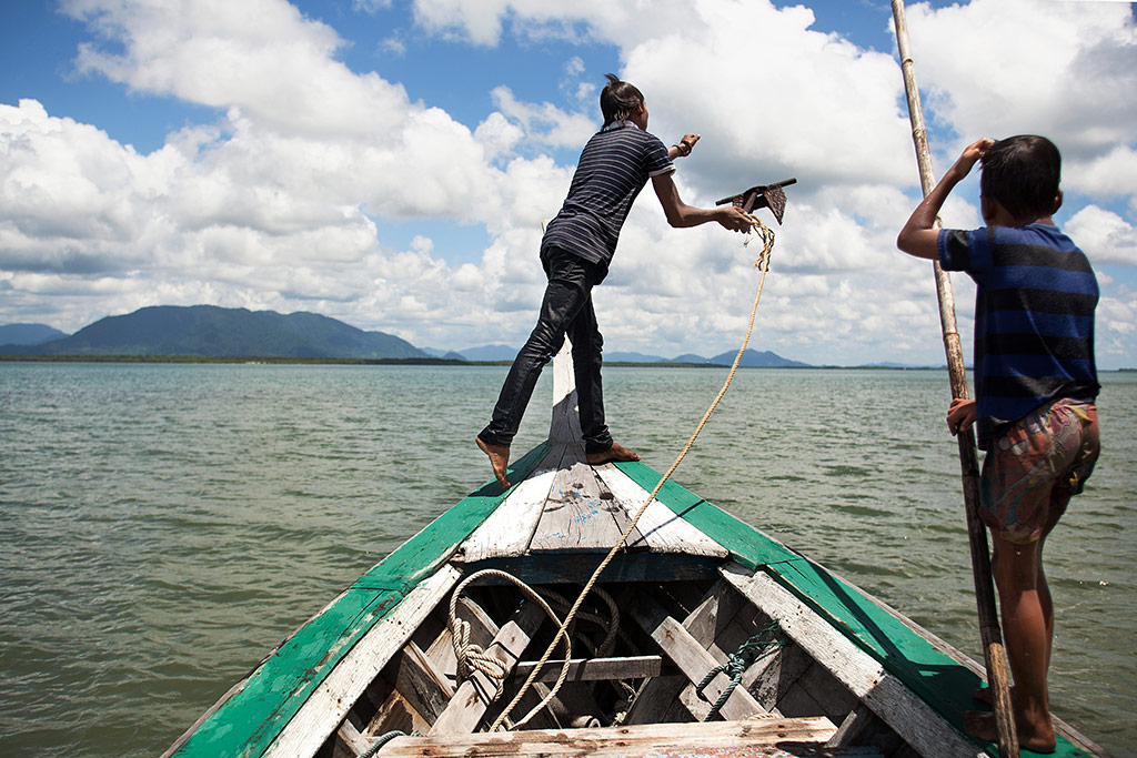 A Moken youth on a boat
