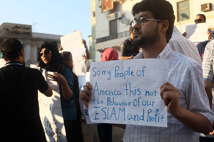 Libya protests: A Libyan man holds a placard in English