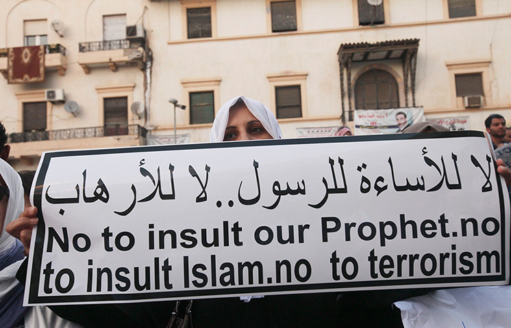 Libya protests: A demonstrator holds banner during a rally, in Benghazi 