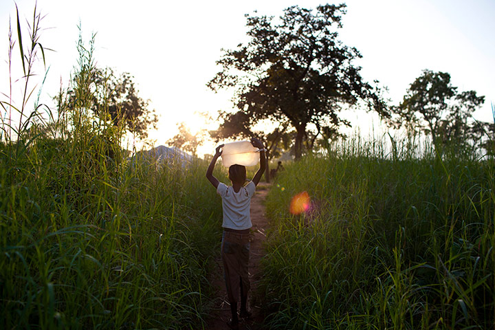 24 Hours: Yida, South Sudan: A young girl carries water back to her home