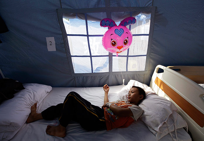 20 photos: A boy rests after receiving treatment after two earthquakes hit Yiliang