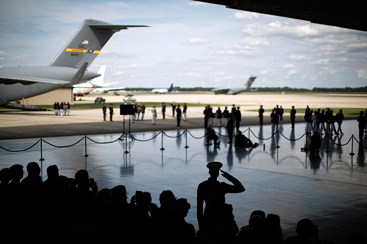 24 Hours: A soldier salutes during a ceremony at Andrews Air Force Base