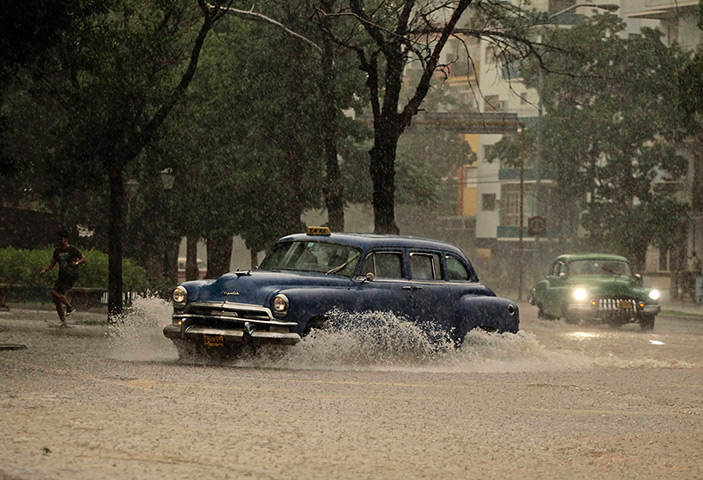 24 hours: Havana, Cuba: Private licensed taxis drive in heavy rain 