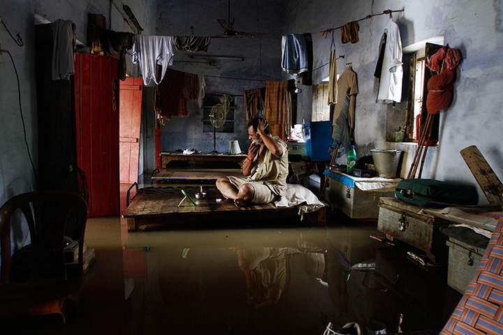 24 hours: Allahabad, India: A policeman shaves while sitting on his bed