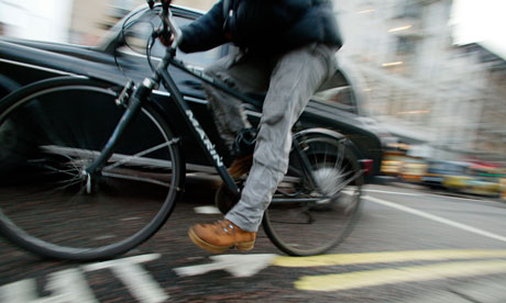 Cyclist black taxi cab Oxford Street West End Central London UK