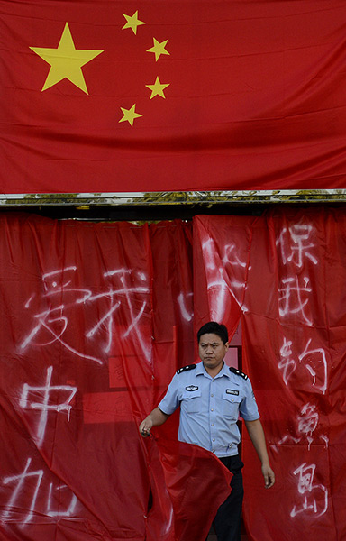 Anti-Japan protests: A Chinese policeman emerges from a closed Japanese restaurant