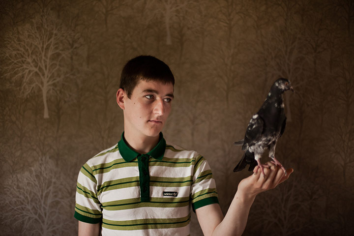 Scottish pigeons: John proudfoot, 19, stands for a portrait in his friends living room