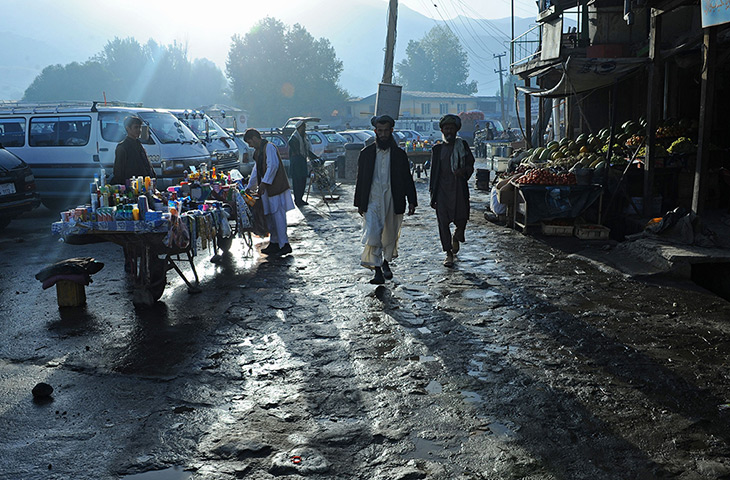 24 hours: Faizabad, Afghanistan: Afghan men walk in a market 