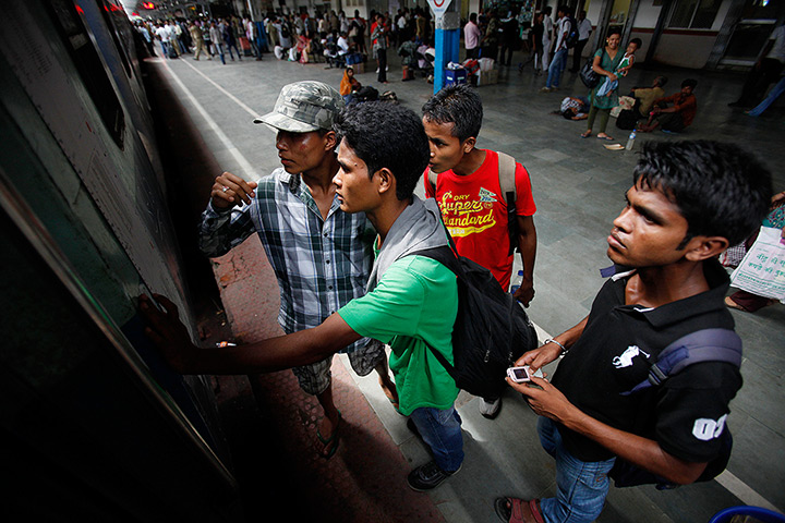 24 hours: Gauhati, India: Students check their names before boarding a special train