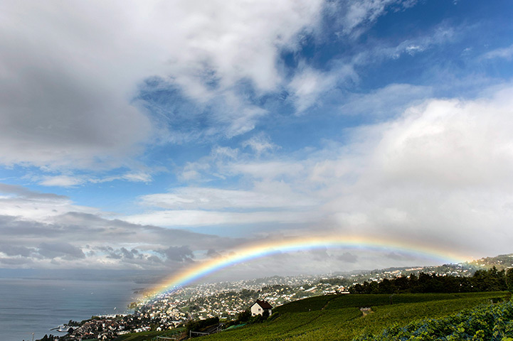 24 hours: Lutry, Switzerland: A rainbow appears over Lake Geneva