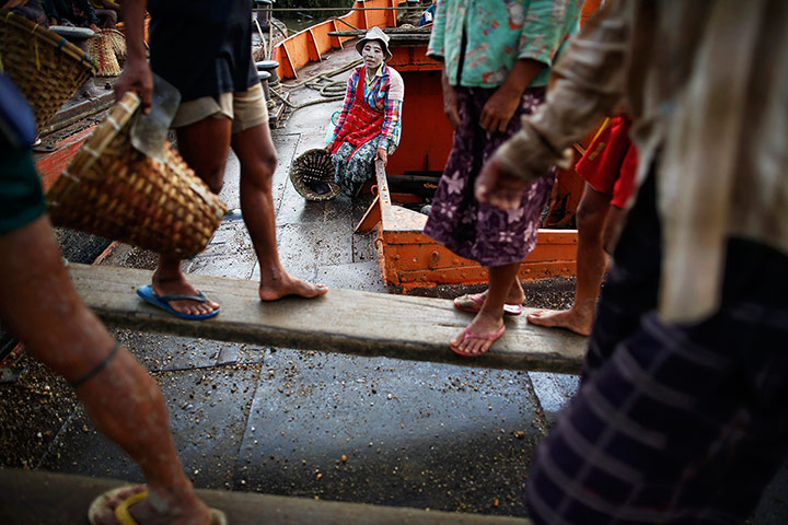 Twenty Photographs: A woman rests after unloading gravel from boats at a port outside Yangon, Burma