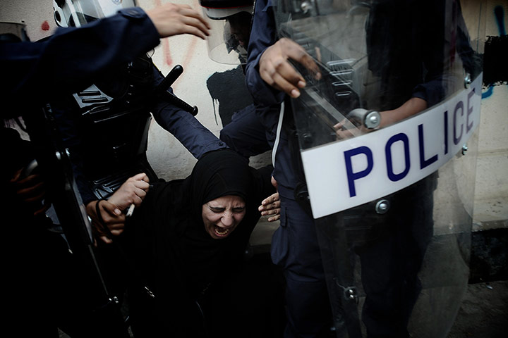 Twenty Photographs: A Bahraini Shia woman is detained by riot police in Manama