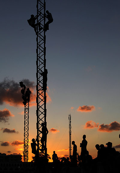 Twenty Photographs: Libyans climb up electricity towers to watch a march against militias in Benghazi