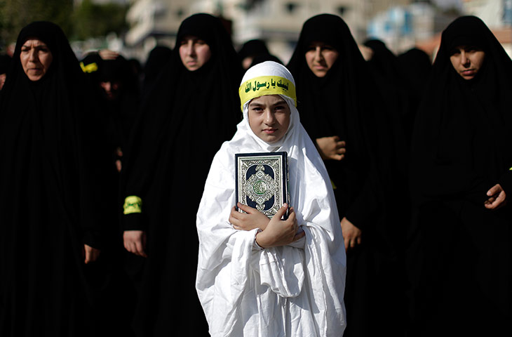 24 hours: Bint Jbeil, Lebanon: A Lebanese girl holds a copy of the Qur'an