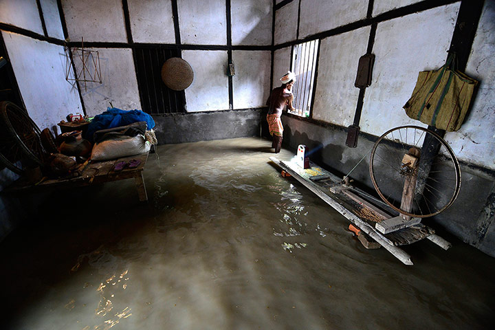 24 hours: Kamrup district, India: A man closes the windows of his flooded home
