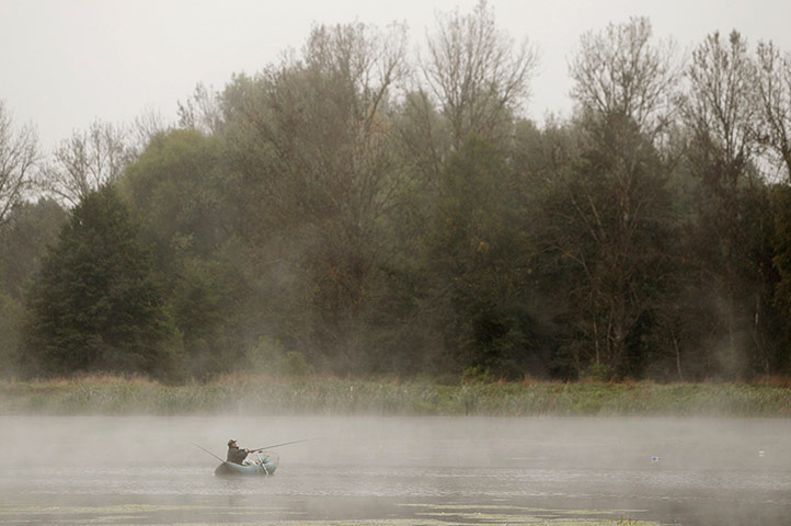 24 hours: Krasnoe, Russia: A fisherman sits in his boat on a lake