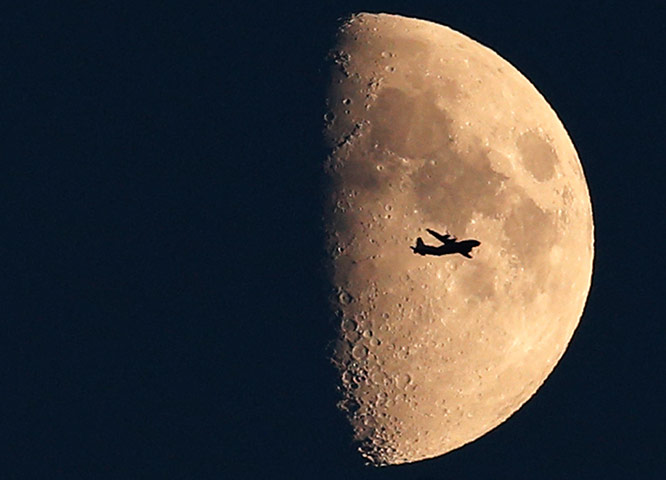 24 hours in pictures: A commercial airplane takes off in front of the moon