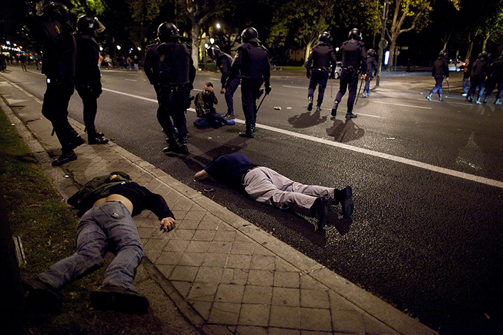 Madrid update: Protesters lay on the ground after riot police baton charged over them