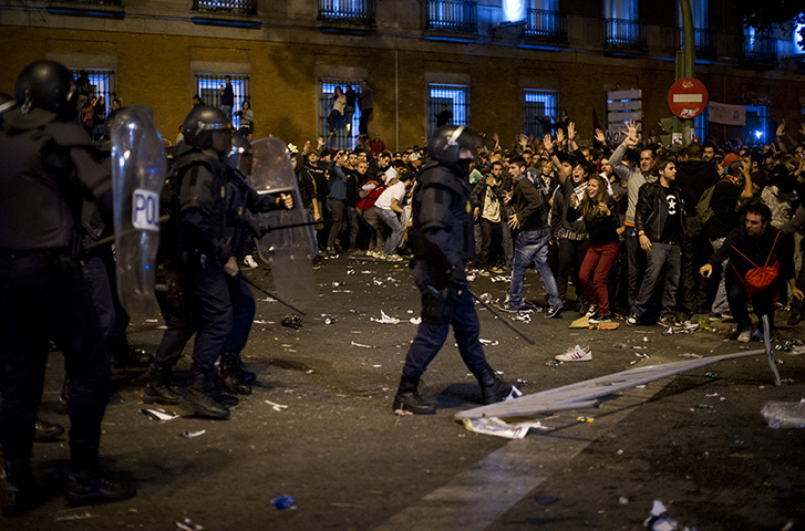 Madrid update: Demonstrators shout at riot policemen during a protest