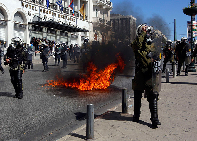 Greece protests: A molotov cocktail explodes beside riot police officers