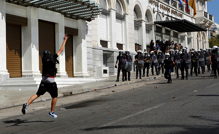 Greece protests update: A demontrator throws a molotov cocktail to riot police