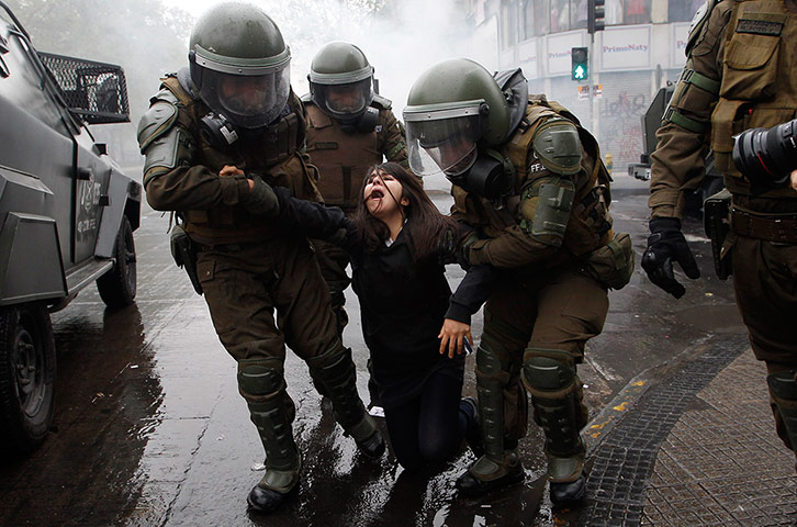 24 hours In Pictures:Riot police arrest a student during education reform protests in Santiago, Chile