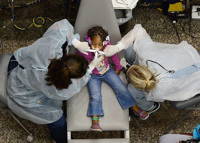 24 hours In Pictures: Kamora Cyprian, aged two, gets her teeth cleaned in Los Angeles