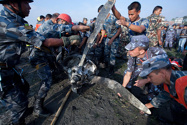 Nepal plane crash: A rescue team lift the propeller