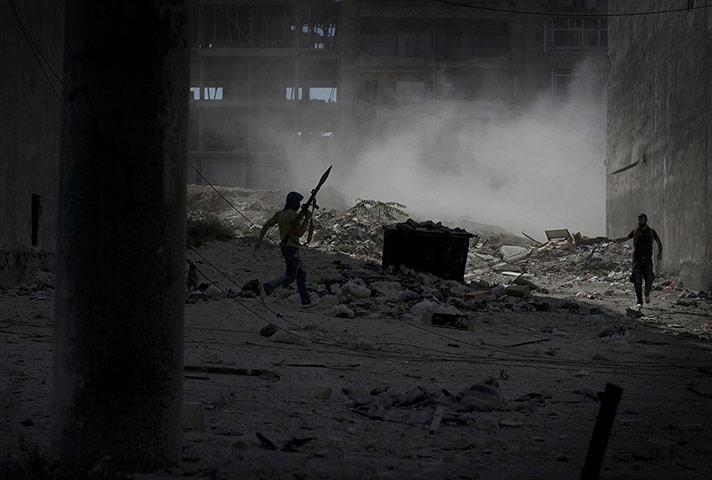 Twenty Photos: A rebel fighter carrying a rocket-propelled grenade in Aleppo