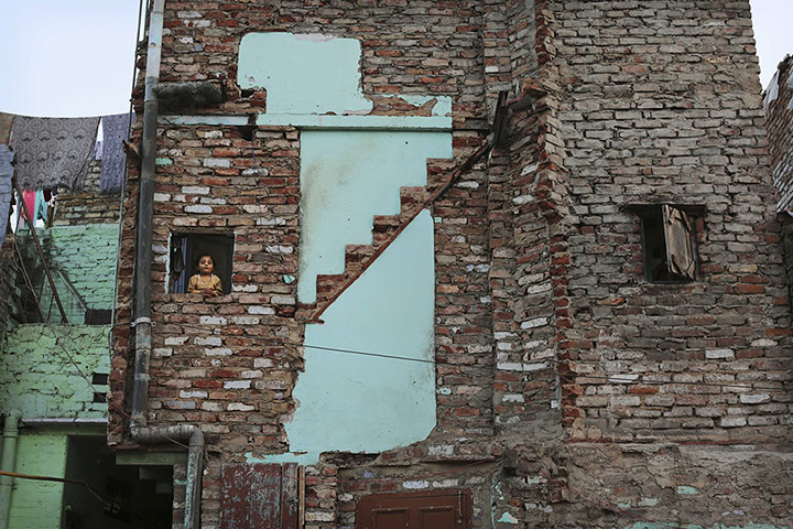 Twenty Photos: An Indian girl looks out from her family's flat where a staircase was