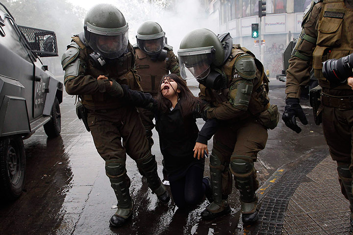 Twenty Photos: Riot policemen arrest a student protester demonstrating in Chile
