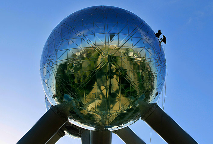 Twenty Photos: Workers stand on one of the spheres of Brussels' Atomium during cleaning