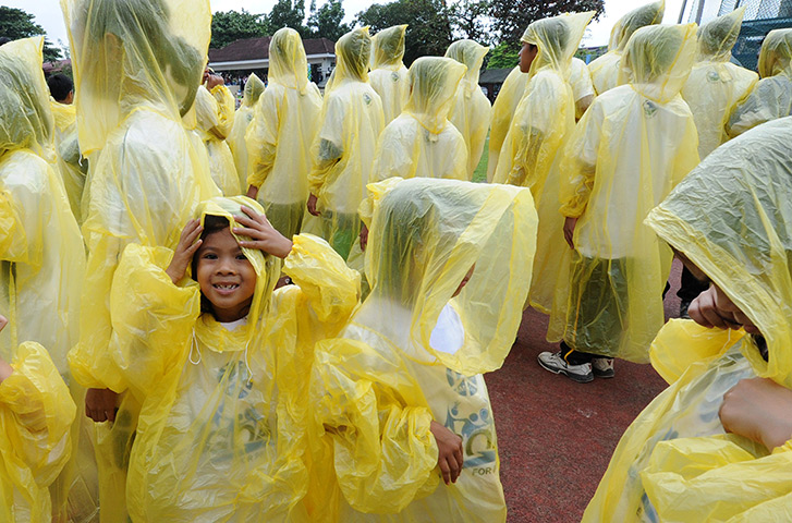 24 hours: Pasig City, Philippines: Filipino schoolchildren wearing raincoats