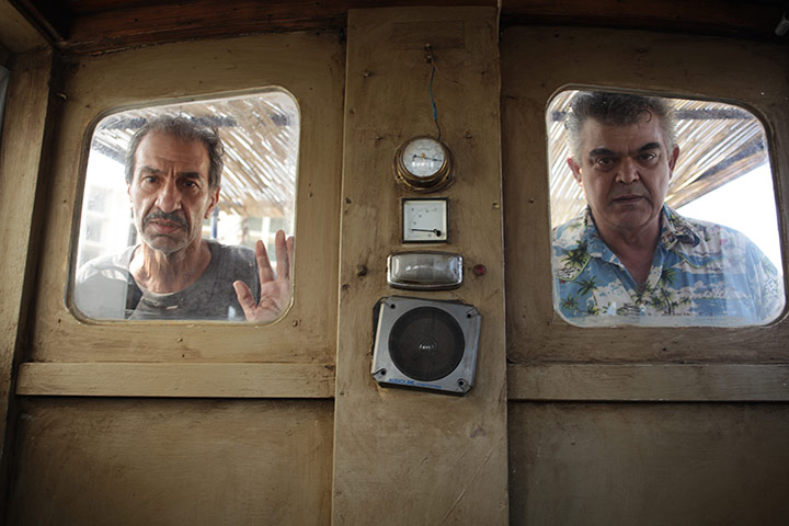 Two men looking through windows from French film When Pigs Have Wings