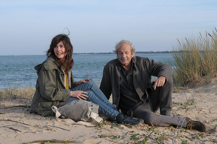 Young girl and older man on a beach from French film Welcome Aboard