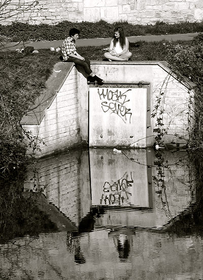 Your Pictures - Urban: A girl and boy sat on a wall above a river