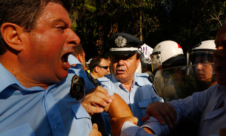 Greek policemen clash with riot police during a protest about austerity cuts in Athens