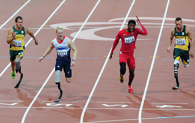 100m: Jonnie Peacock looks across at the time as he crosses the line 
