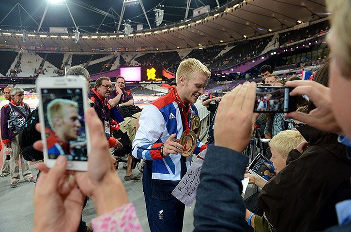 100m final batch 3: Fans take photographs of Great Britain's Jonnie Peacock